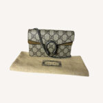 Designer Gucci mini crossbody bag in beige GG canvas with silver chain strap