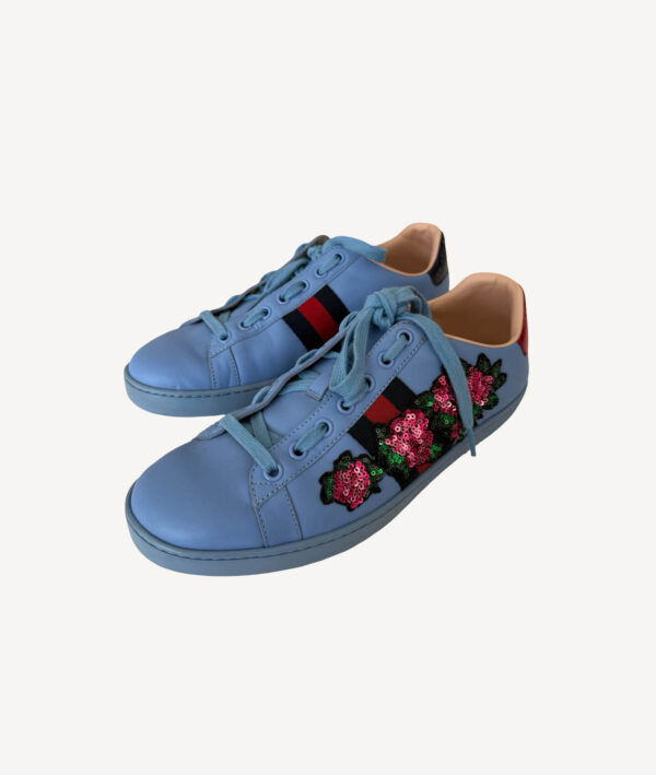 Gucci Ace blue leather sneakers with floral sequin embroidery and signature web stripe — authentic luxury designer trainers.